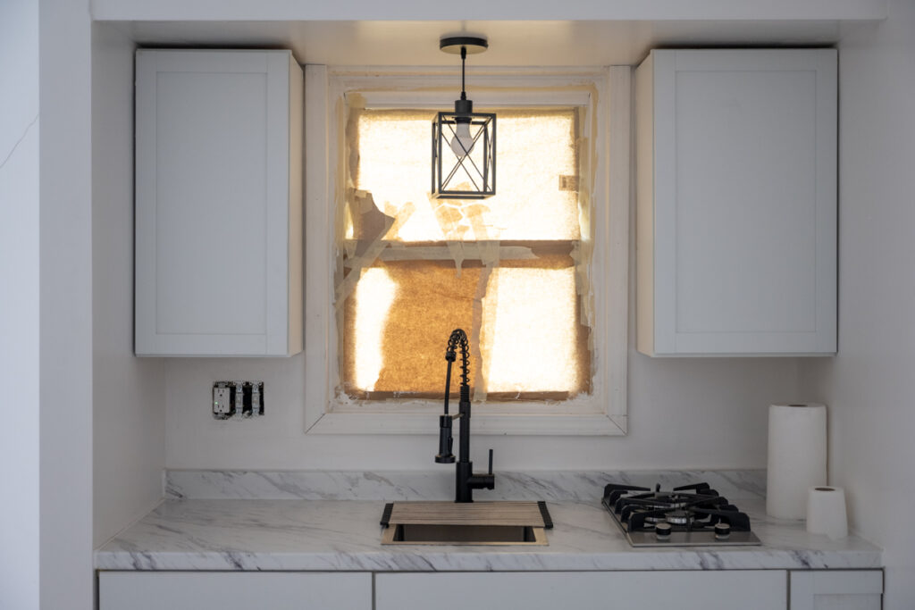 Interior of apartment showing restoration results in the kitchen sink and stove area.