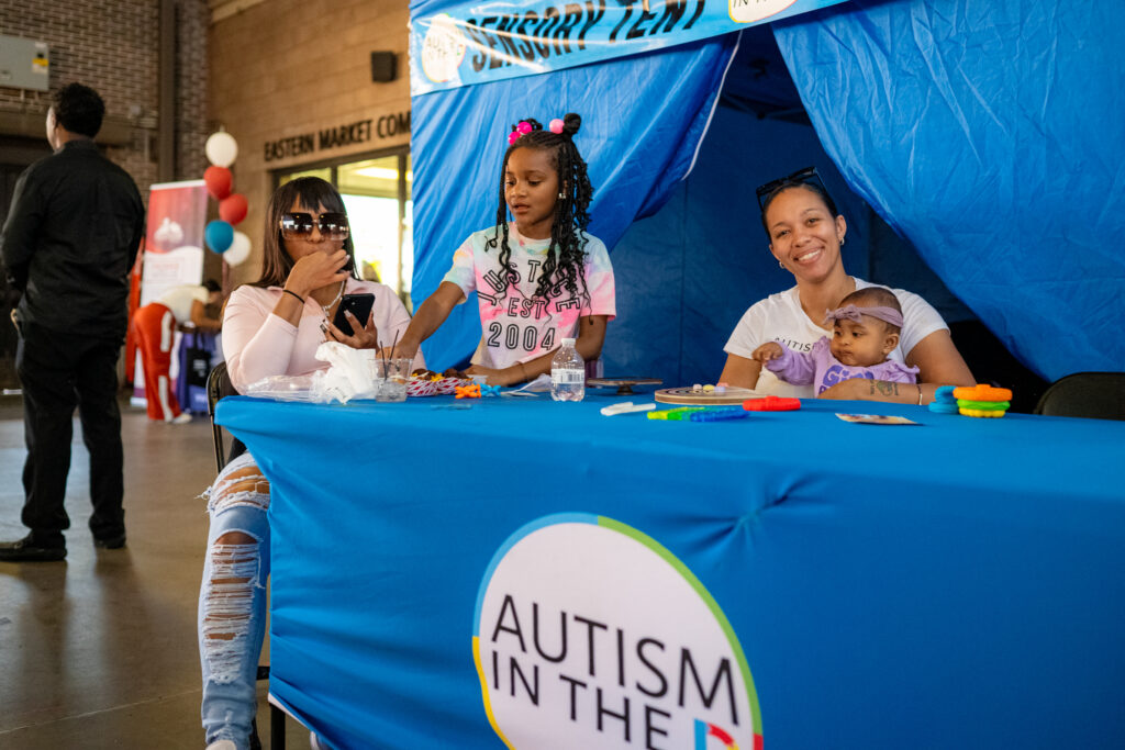Family and children engage at Autism in the D sensory booth during ProsperUs’ 2025 Family Block Party at Eastern Market.